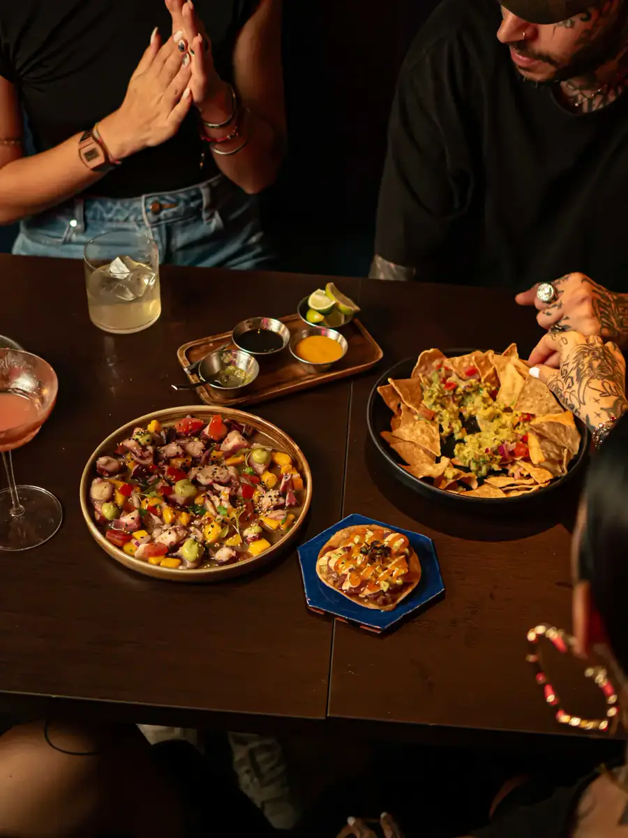 Mesa larga de grupo cenando a la luz de las velas en Piñata Cantina