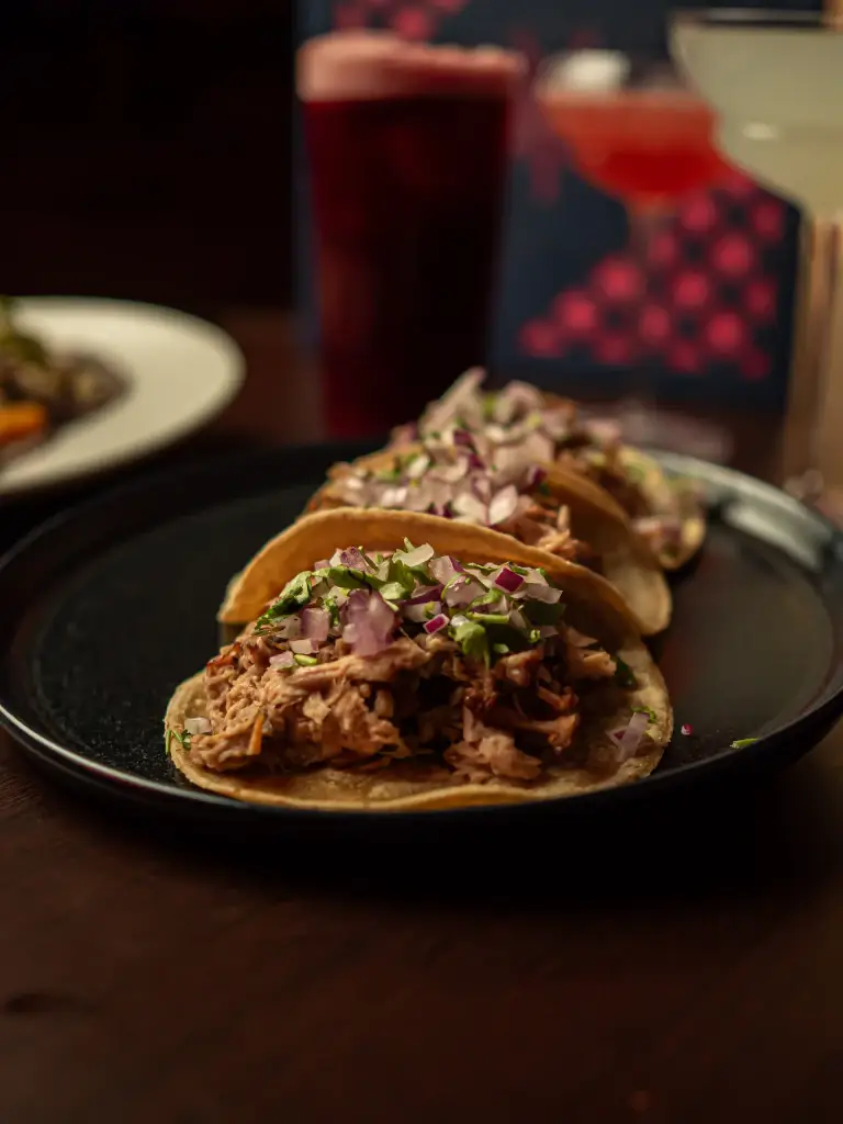 Tacos de carnitas con cebolla morada del Taco Tuesday de Piñata Cantina