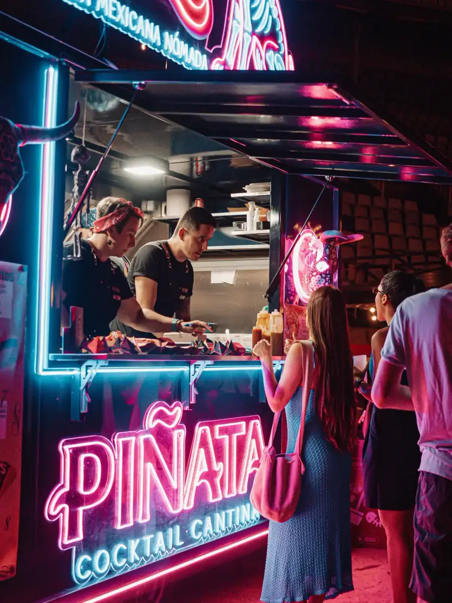 Food truck Xolo de Piñata Cantina iluminado de noche en un evento
